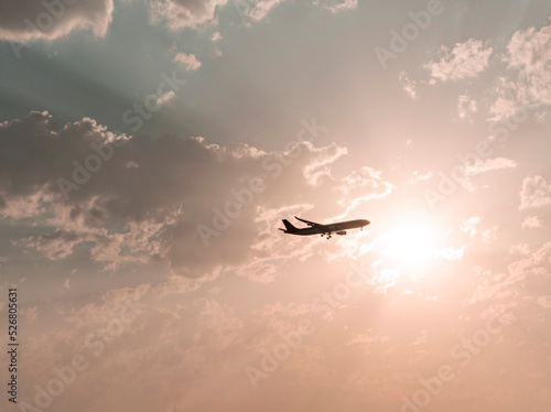 Airplane flying in the sky against the backdrop of beautiful pink sunset among the clouds natural background copy space