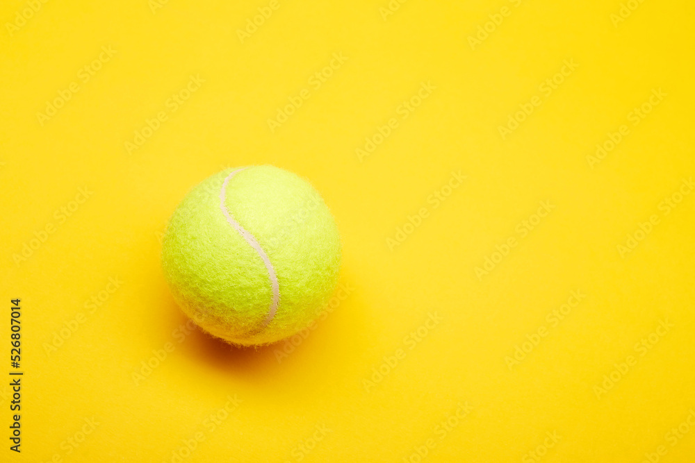 Extreme close up tennis ball isolated on the bright solid fond plain yellow background. Sport inventory and equipment concept