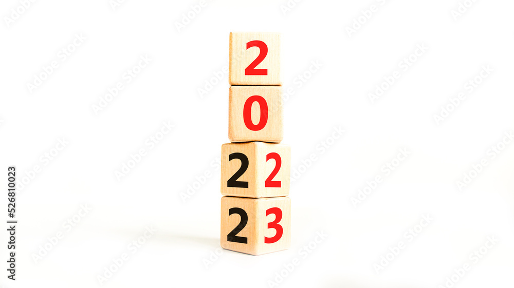 2023 happy new year symbol. Wooden cubes symbolize the change from 2022 to the new year 2023. Beautiful white table white background. Copy space. Business and 2023 happy new year concept. 2023 happy new year symbol. Wooden cubes symbolize the change from 2022 to the new year 2023. Beautiful white table white background. Copy space. Business and 2023 happy new year concept.