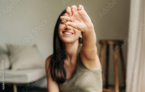 Happy healthy woman recommending omega 3 fish oil and holding out a pill in her hand photo