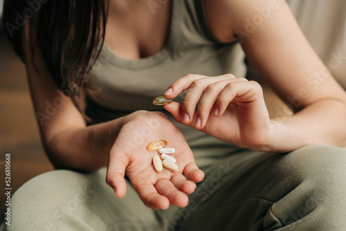 Fotografi Closeup unrecognizable caucasian woman holding omega-3 fish oil capsules in hand