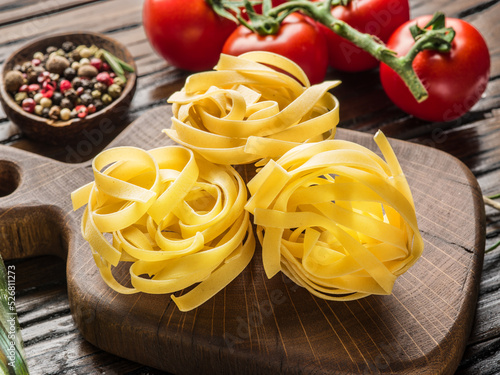 Tagliatelle pasta on wooden board close-up.