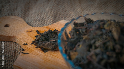 Dried roasted green tea leaves on the bowl on burlap background, Japanese tea, Houji tea