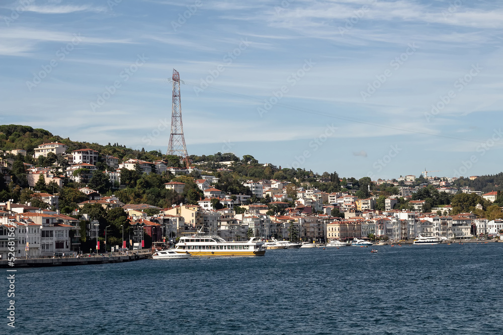 View of moored boats on Bosphorus and Arnavutkoy neighborhood on European side of Istanbul. It is a sunny summer day. Beautiful travel scene.