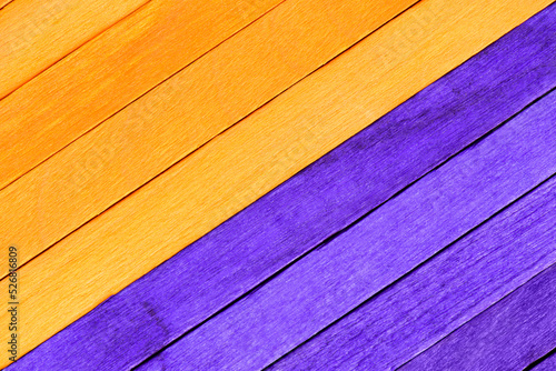 Halloween old wooden textured planks background. Wooden planks painted orange and purple are arranged diagonally. Colored boards in two traditional Halloween or Day of the Dead colors.