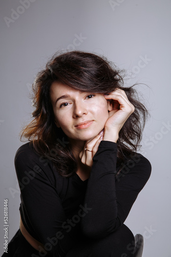 emotional beautiful girl in black clothes on a gray background © Andrii