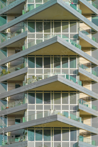 Glass green balconies windows of facade modern city building. Facade of building texture closeup