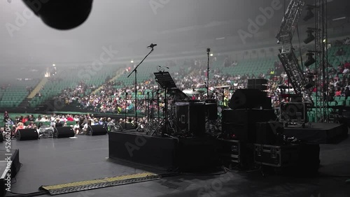 drum kit on the stage of the stadium. huge concert hall. large crowd of people at the concert. sound check of musicians. waiting before performance.