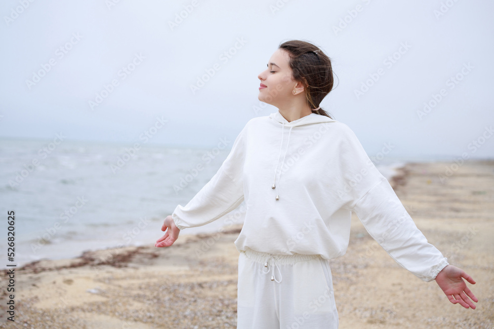 Sweet girl taking deep breathe at the beach in the morning Sweet girl taking deep breathe at the beach in the morning