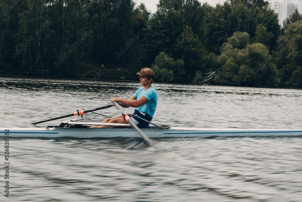 Sportsman single scull man rower rowing on boat. Sportsman single scull man rower rowing on boat.
