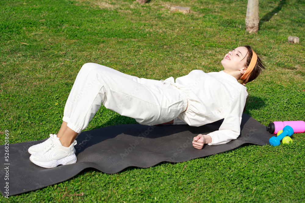 Young girl laying on the yoga mat and doing exercises Young girl laying on the yoga mat and doing exercises