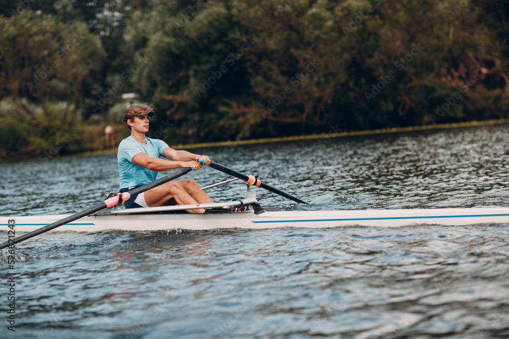 Sportsman single scull man rower rowing on boat. Sportsman single scull man rower rowing on boat.
