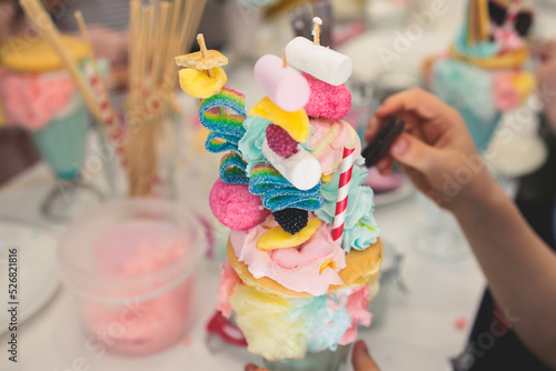Over shake and freak shake, process of cooking extreme colorful milkshakes on a kids birthday party celebration, catering banquet table with candy sweets desserts, monster shakes
