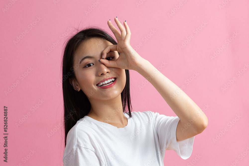 Fototapeta premium Portrait of asian woman with ok gesture on pink background.