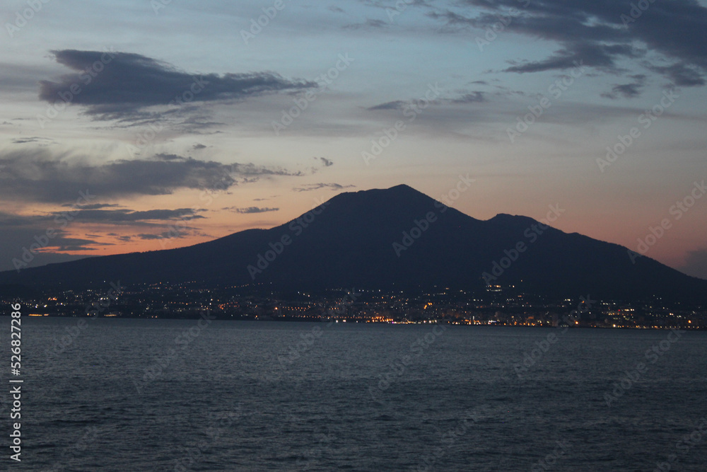 Mount Vesuvius, near Naples (last erupted in 1944); the only volcano to have recently erupted in Continental Europe image shows the volcano across the sea with a beautiful sunset. August 2022