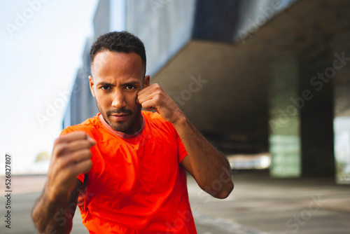 Man doing shadow boxing outdoos in city photo