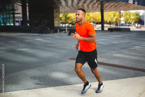 Fit man athlete jogging outdoors in city