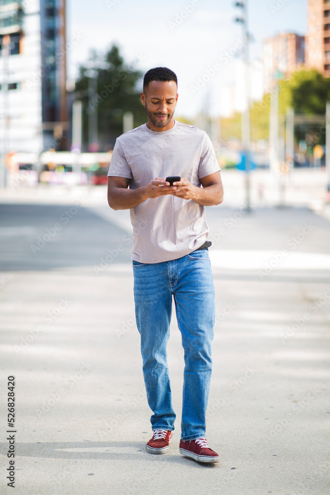 Man text messaging using mobile phone outdoors in city Man text messaging using mobile phone outdoors in city