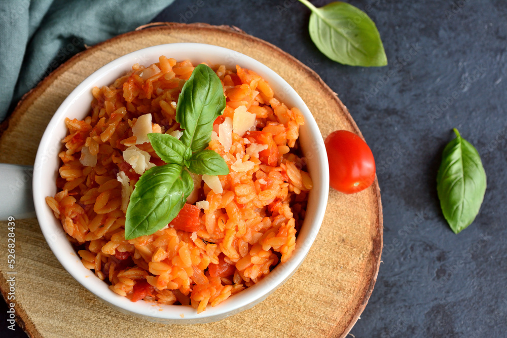 Kritharaki with tomatoes and chicken. Traditional type of Greek pasta shape of rice. Greek version of Italian Orzo