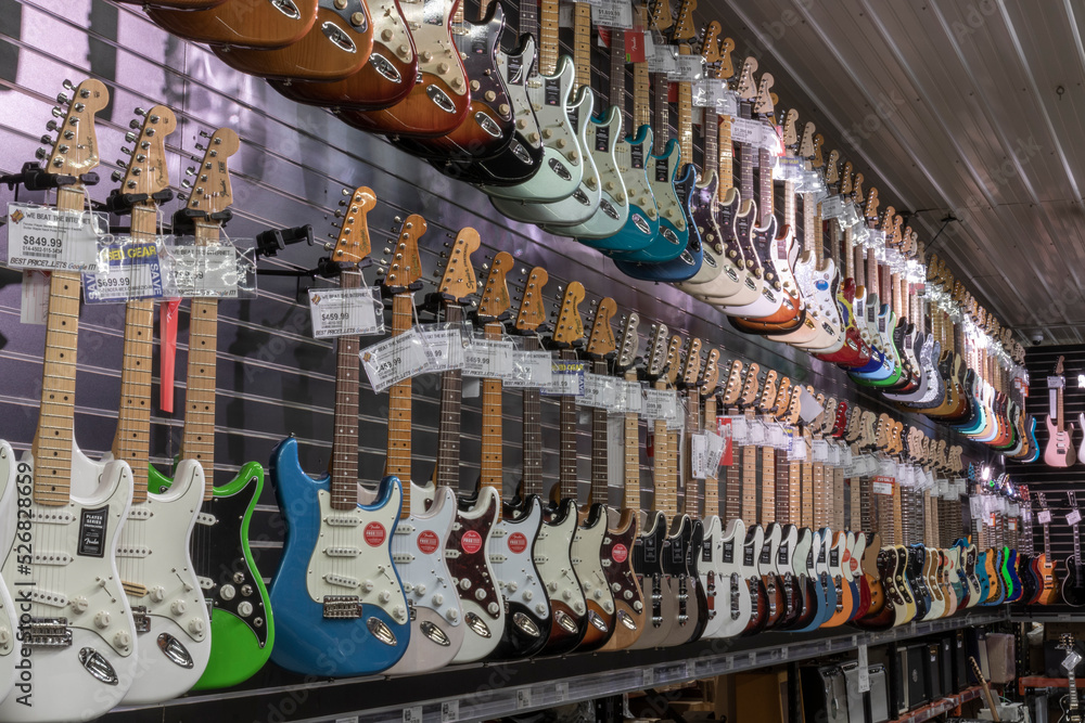 Fender Stratocaster guitar display at a music store. Strats are world  renowned for their distinctive clean sound. Stock Photo | Adobe Stock