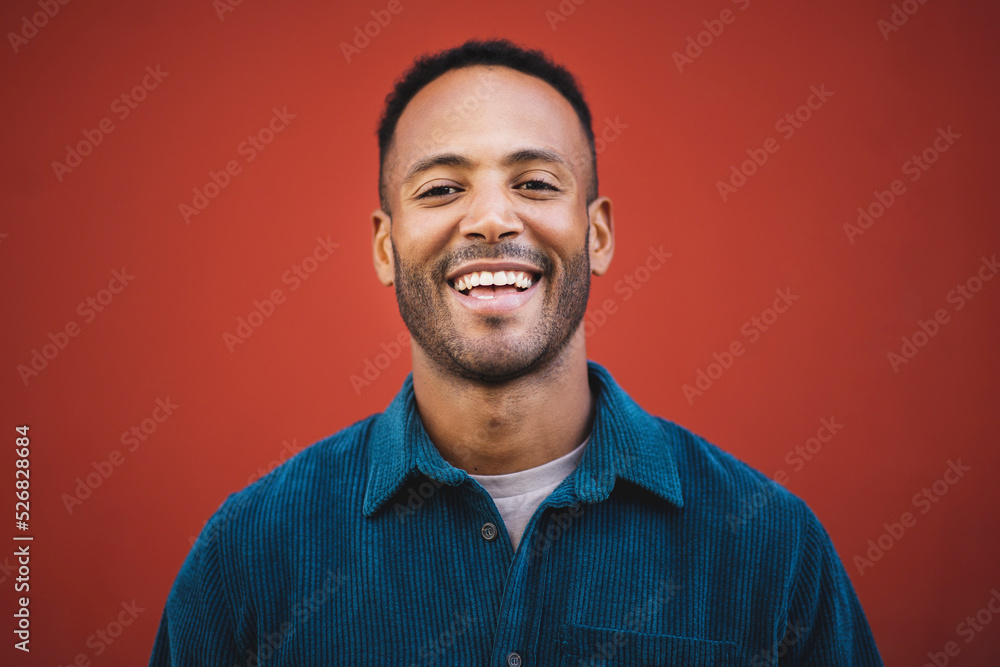 Obraz premium Young man laughing over maroon background