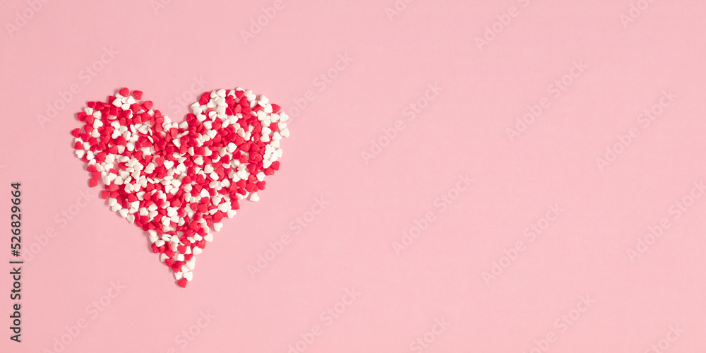 Valentine's Day background. Composition with candy hearts. Symbol heart of sweets  on pastel pink background. Flat lay, top view