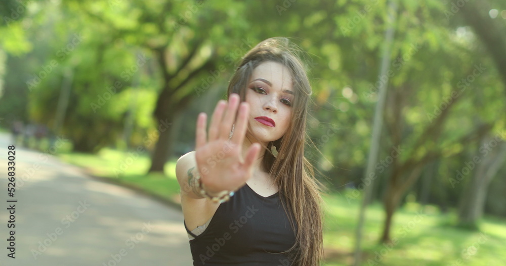 Latin woman disapproving with no hand sign waving finger gesture signalling STOP Latin woman disapproving with no hand sign waving finger gesture signalling STOP
