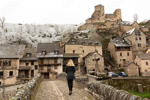 Mujer paseando por Belcastel nevado, Francia. photo