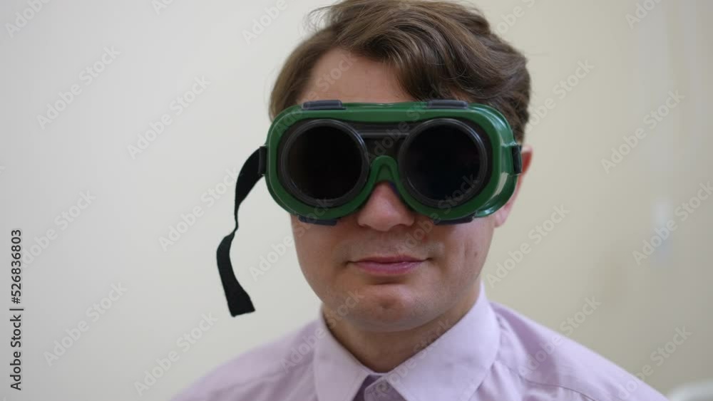 Front view headshot of confident man looking at camera putting on glasses for color blindness test. Caucasian male patient posing in hospital undergoing medical examination