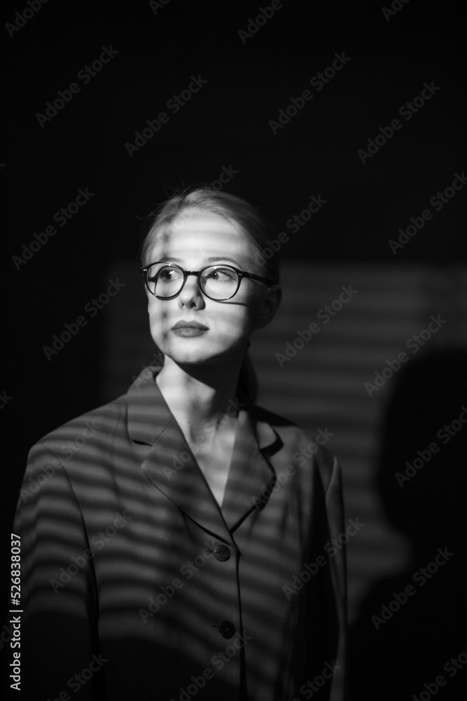 Fototapeta premium portrait of woman in noir style with shadow from blinds