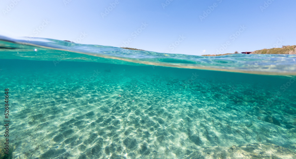 Split underwater view of La Speranza sandy seabed