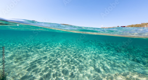 Split underwater view of La Speranza sandy seabed