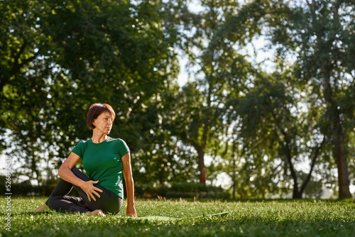 Mature woman practicing yoga in sage marichis pose