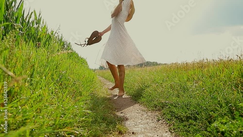 Closeup of barefoot woman walking country path in field. Concept of healthy lifestyle, freedom and relaxation in nature.