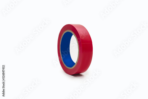 Skein of red electrical tape on a white background. Tool for insulating wiring in electrical systems. Coil of electrical tape for electrical work during construction or repair