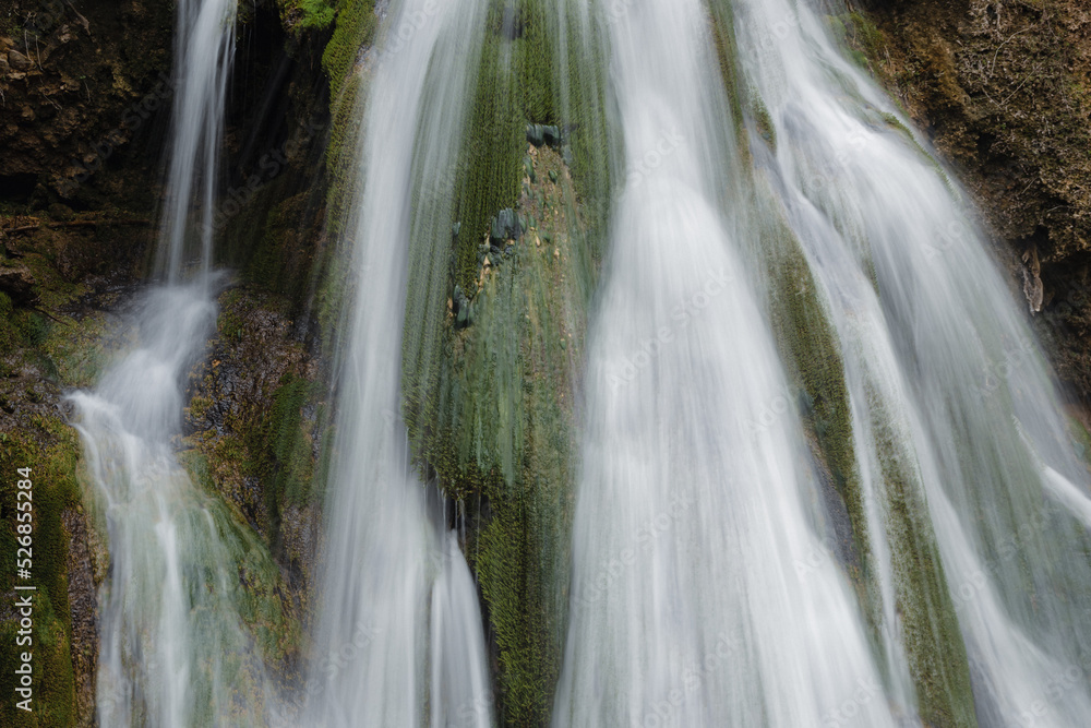 Beautiful waterfall splashing over mossy rocks