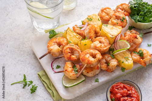 kebab skewers of barbecued shrimp with a pineapple photo