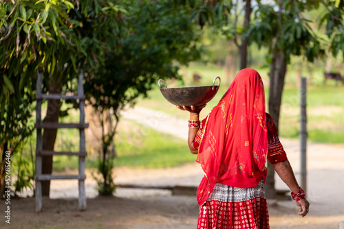 Woman carrying cauldron in Indian village