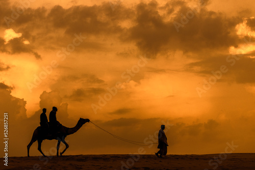 Camel guide at sunset in Thar desert, Jaisalmer (Rajasthan, India) photo