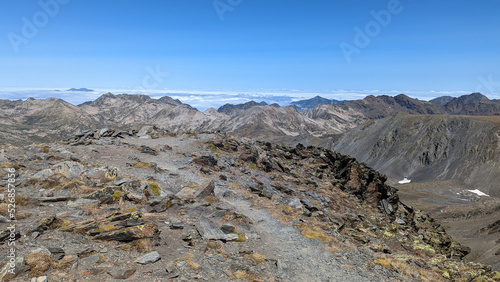 un sentier au sommet d'une montagne avec un paysage montagneux en arrière plan