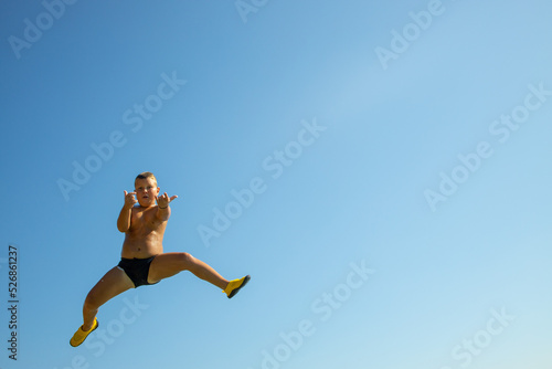 Jump into the water. a boy caught jumping into the water. caught in the moment of flight