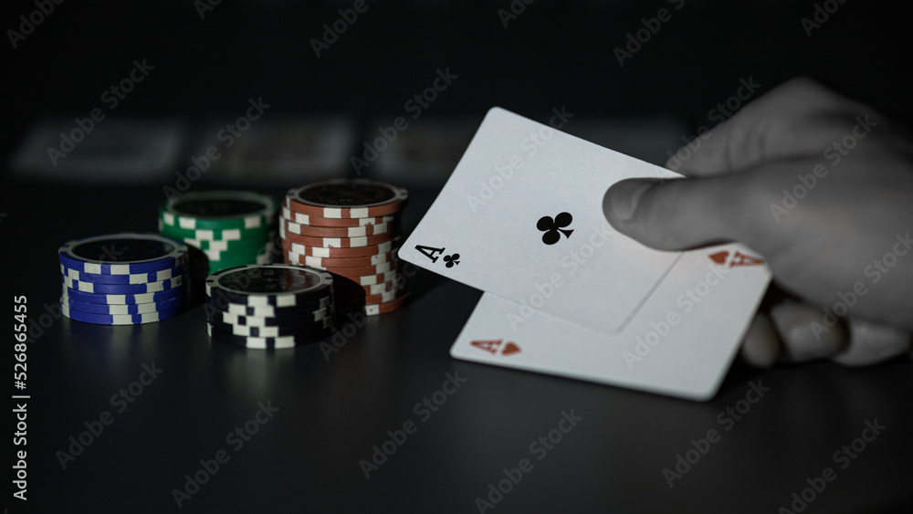 Obraz premium Dealer or croupier shuffles poker cards in a casino on the background of a table, chips. Concept of poker game, game business. Playing for money, a big win, a jackpot, gambling, a desire to get rich