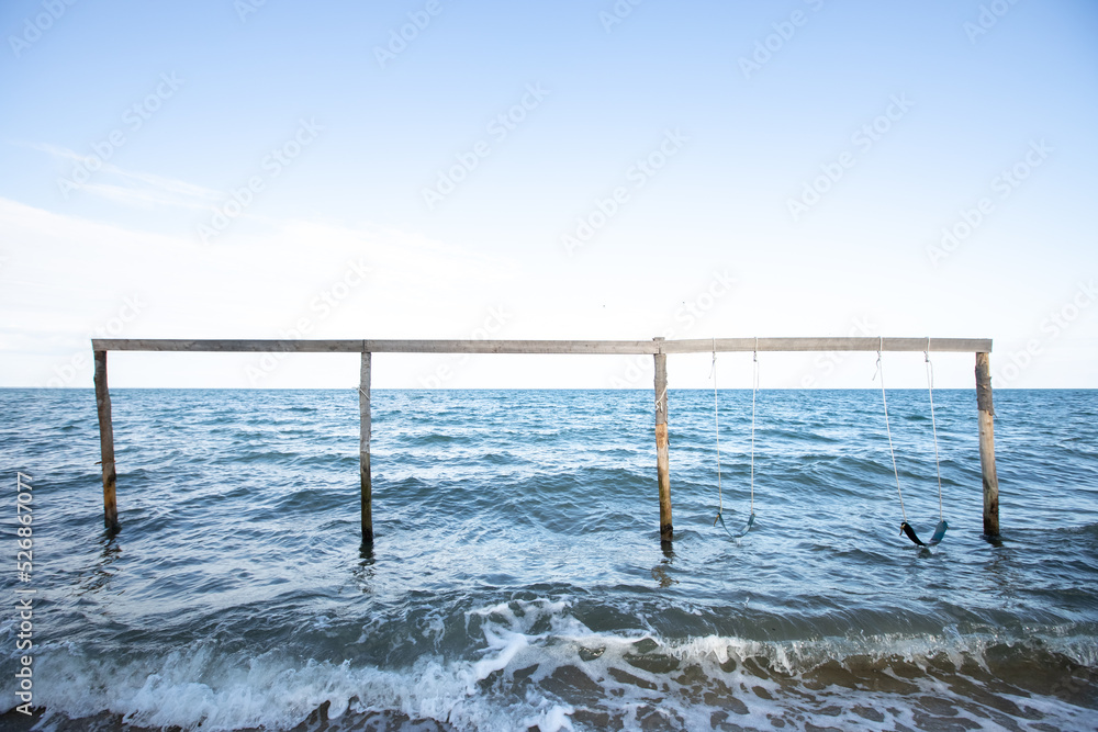 Wooden swing set on the ocean in Hopkins Belize Wooden swing set on the ocean in Hopkins Belize