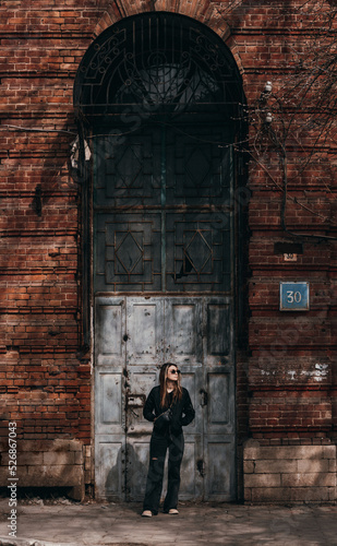 a young girl stands near an old building © Cavan