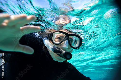 young woman in wet suit snorkling off the coast of Hopkins in Belize