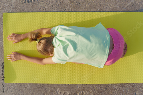 A girl doing yoga on a yoga mat, top view. photo