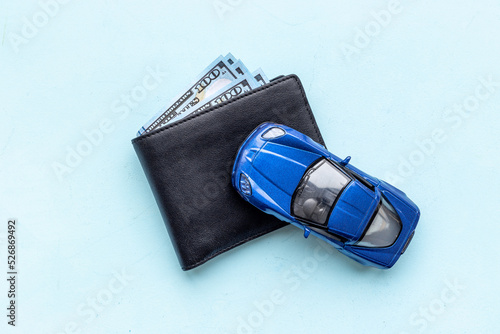 Toy car with wallet and money. Purchase a car concept