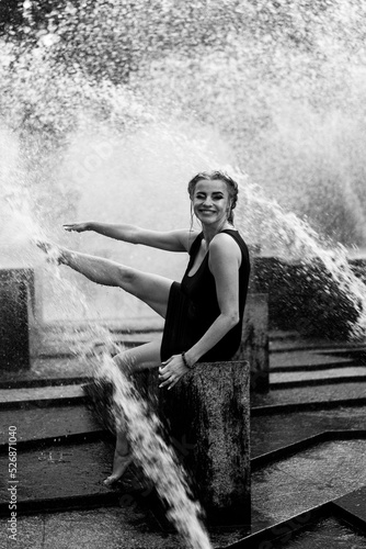 Happy woman having fun at the city fountain on a summer day. © Yuliya Kirayonak