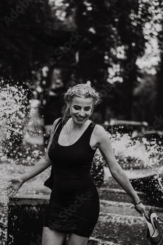 Happy woman having fun at the city fountain on a summer day. © Yuliya Kirayonak