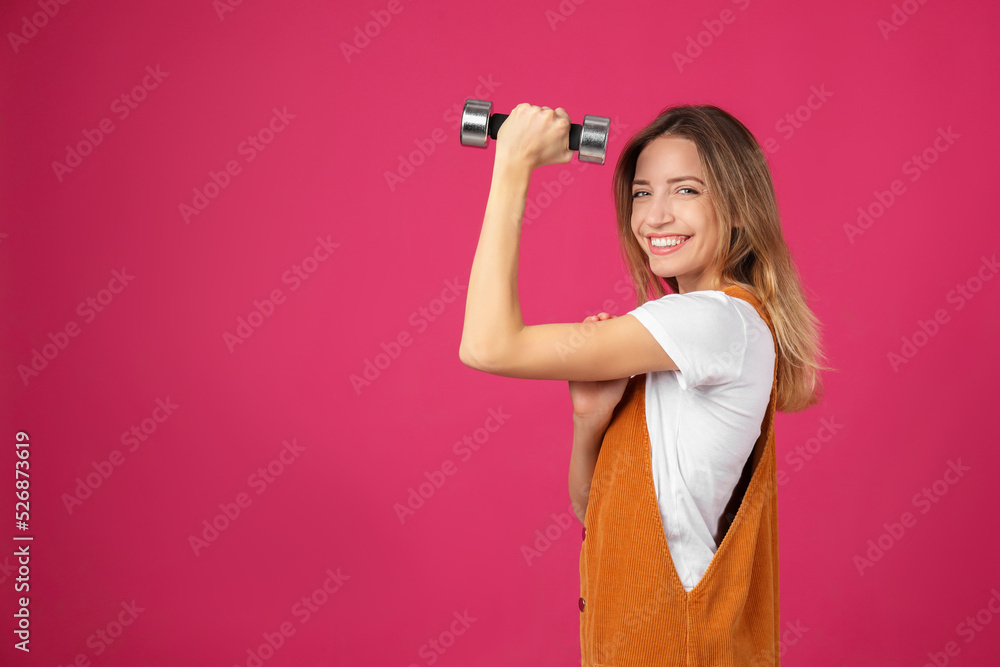 Woman with dumbbell as symbol of girl power on pink background, space for text. 8 March concept Woman with dumbbell as symbol of girl power on pink background, space for text. 8 March concept